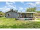 Quaint home exterior showing a cozy, screened porch with a spacious backyard and blue siding at 660 6Th St, Daytona Beach, FL 32117
