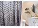 Well-lit bathroom featuring a white vanity, round mirror, and stylish dark shower curtain at 660 6Th St, Daytona Beach, FL 32117