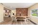 Dining area featuring a rustic table, brick accent wall, and wood-look flooring at 660 6Th St, Daytona Beach, FL 32117