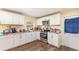 Functional kitchen featuring white cabinets, stainless steel appliances, and wood-look floors at 660 6Th St, Daytona Beach, FL 32117