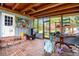 Screened-in porch with brick floors, wood ceilings, and colorful decor, ideal for relaxation at 660 6Th St, Daytona Beach, FL 32117