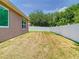 A fenced backyard features a spacious lawn enclosed by a white vinyl fence, with room for outdoor activities at 6843 Cherry Grove Cir, Orlando, FL 32809