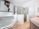 Well-lit bathroom with a soaking tub, glass-enclosed shower, and double sinks, offering a spa-like experience at 6843 Cherry Grove Cir, Orlando, FL 32809