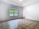Expansive bedroom with neutral walls, tray ceiling, and a large window with a view of lush greenery at 6843 Cherry Grove Cir, Orlando, FL 32809