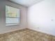 Bedroom features tile floors, a large window, and blank walls with an electrical outlet at 6843 Cherry Grove Cir, Orlando, FL 32809