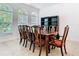 Dining room features large windows for natural lighting, tile flooring, and a dark wooden table with seating for eight at 6843 Cherry Grove Cir, Orlando, FL 32809