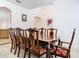 Formal dining room featuring a wooden table and chairs for eight, tile flooring, and bright white walls at 6843 Cherry Grove Cir, Orlando, FL 32809