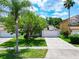 Well-maintained home featuring manicured lawn, two car garage, and palm trees on a sunny day at 6843 Cherry Grove Cir, Orlando, FL 32809