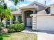 Charming home exterior with manicured landscaping, double-door entry, and a two-car garage at 6843 Cherry Grove Cir, Orlando, FL 32809