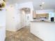 Hallway features light walls, tiled floor, with doors and kitchen in the background at 6843 Cherry Grove Cir, Orlando, FL 32809
