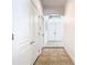 Hallway with tile flooring, white walls and doors, leading to the front entrance at 6843 Cherry Grove Cir, Orlando, FL 32809