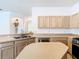 Close-up view of the kitchen featuring stainless steel appliances, and light wood cabinets at 6843 Cherry Grove Cir, Orlando, FL 32809