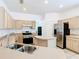 Well-lit kitchen features stainless steel appliances, light wood cabinetry, and a practical kitchen island at 6843 Cherry Grove Cir, Orlando, FL 32809