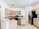 Well-lit kitchen features stainless steel appliances, light wood cabinetry, and a practical kitchen island at 6843 Cherry Grove Cir, Orlando, FL 32809