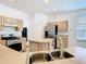 Updated kitchen with stainless steel appliances, center island, and light wood cabinets at 6843 Cherry Grove Cir, Orlando, FL 32809