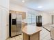 Kitchen island view with stainless refrigerator and view to the living area at 6843 Cherry Grove Cir, Orlando, FL 32809