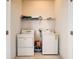 Practical laundry room with washer, dryer, and shelving, offering ample space for laundry needs at 6843 Cherry Grove Cir, Orlando, FL 32809