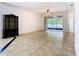Spacious living room features ceramic tiled floors and a screened lanai with views at 6843 Cherry Grove Cir, Orlando, FL 32809