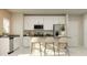 Modern kitchen with white cabinets, stainless steel appliances, and a breakfast bar with seating at 7183 Rosy Sky Ave, Orlando, FL 32829