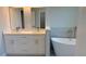 Bathroom with a double sink vanity and freestanding tub, complemented by sleek tiling and modern fixtures at 7418 Sw 129Th Ln, Ocala, FL 34473