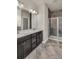 Bathroom featuring a double vanity with dark wood cabinets and a modern glass-enclosed shower at 8230 Corkfield Ave, Orlando, FL 32832