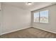 Bedroom featuring neutral walls, carpet flooring, and a window with natural light and views of the neighborhood at 8230 Corkfield Ave, Orlando, FL 32832