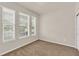 Cozy bedroom with carpeted floors, three windows providing natural light, and a closet at 8230 Corkfield Ave, Orlando, FL 32832