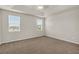Spacious bedroom featuring a tray ceiling, carpet flooring, and two windows with natural lighting at 8230 Corkfield Ave, Orlando, FL 32832