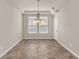 Bright dining room with tile flooring, decorative chandelier, large windows and tray ceiling at 8230 Corkfield Ave, Orlando, FL 32832