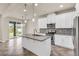 Modern kitchen featuring stainless steel appliances, a gray backsplash, and a center island at 8230 Corkfield Ave, Orlando, FL 32832