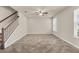 Spacious living room features tile flooring, a ceiling fan, and a staircase at 8230 Corkfield Ave, Orlando, FL 32832