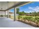 Covered outdoor patio overlooking a spacious backyard with lush landscaping and privacy fence at 8230 Corkfield Ave, Orlando, FL 32832