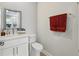 This bathroom features a white vanity with a mirror, a toilet, and a decorative towel rack at 8418 Via Bella Notte, Orlando, FL 32836