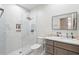 Bright bathroom featuring white marble walls, a walk-in glass shower and a modern vanity with sink and mirror at 8418 Via Bella Notte, Orlando, FL 32836