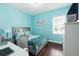 Cozy bedroom featuring wood floors, soft blue walls, and a comfortable double bed by a bright window at 8418 Via Bella Notte, Orlando, FL 32836