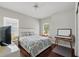 Modern bedroom featuring a double bed, hardwood floors, a window with blinds and a writing desk with shelving at 8418 Via Bella Notte, Orlando, FL 32836