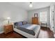 Cozy bedroom featuring dark hardwood floors, a double bed, a window with blinds and side tables with lamps at 8418 Via Bella Notte, Orlando, FL 32836