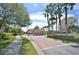 Picturesque view of a gated community entrance with brick paved road and lush landscaping at 8418 Via Bella Notte, Orlando, FL 32836