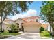 Well-maintained home features a tile roof, two car garage, and brick driveway with landscaping at 8418 Via Bella Notte, Orlando, FL 32836