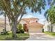 Charming home boasts a red tile roof, manicured lawn, and inviting red double-door entry at 8418 Via Bella Notte, Orlando, FL 32836