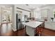 Bright kitchen features stainless steel appliances, white cabinetry, island seating, and hardwood floors at 8418 Via Bella Notte, Orlando, FL 32836