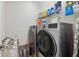 Modern laundry room showcasing stainless steel washer and dryer with storage shelves at 8418 Via Bella Notte, Orlando, FL 32836