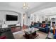 Spacious living area with hardwood floors, a large TV, and an open layout for entertaining and relaxation at 8418 Via Bella Notte, Orlando, FL 32836