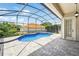 Screened-in kidney shaped pool with patio and view of a house with a red tile roof at 8418 Via Bella Notte, Orlando, FL 32836