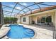 Screened-in kidney shaped pool with patio and view of a house with a red tile roof at 8418 Via Bella Notte, Orlando, FL 32836