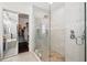 Luxurious walk-in shower featuring marble walls, pebble flooring, a glass door and shelving for toiletries at 8418 Via Bella Notte, Orlando, FL 32836