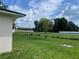 Spacious backyard with green lawn and a chain link fence on a sunny day with blue sky and fluffy white clouds at 909 San Paulo Way, Kissimmee, FL 34758