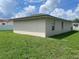 Exterior of home featuring a concrete block wall, grass yard, and cloudy sky at 909 San Paulo Way, Kissimmee, FL 34758