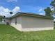 Tan home with dark roof and a green lawn on a sunny day with blue sky and fluffy white clouds at 909 San Paulo Way, Kissimmee, FL 34758
