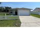 Charming single-story home featuring a white picket fence, green lawn, and attached two-car garage at 909 San Paulo Way, Kissimmee, FL 34758